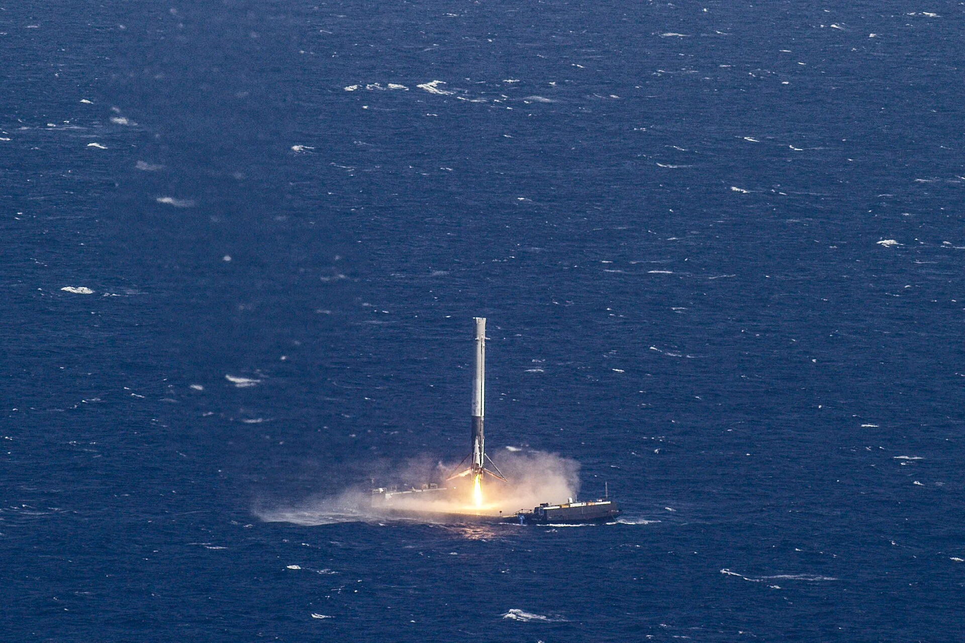 A Falcon 9 booster descends onto a drone ship at sea during the CRS-8 mission in April 2016.