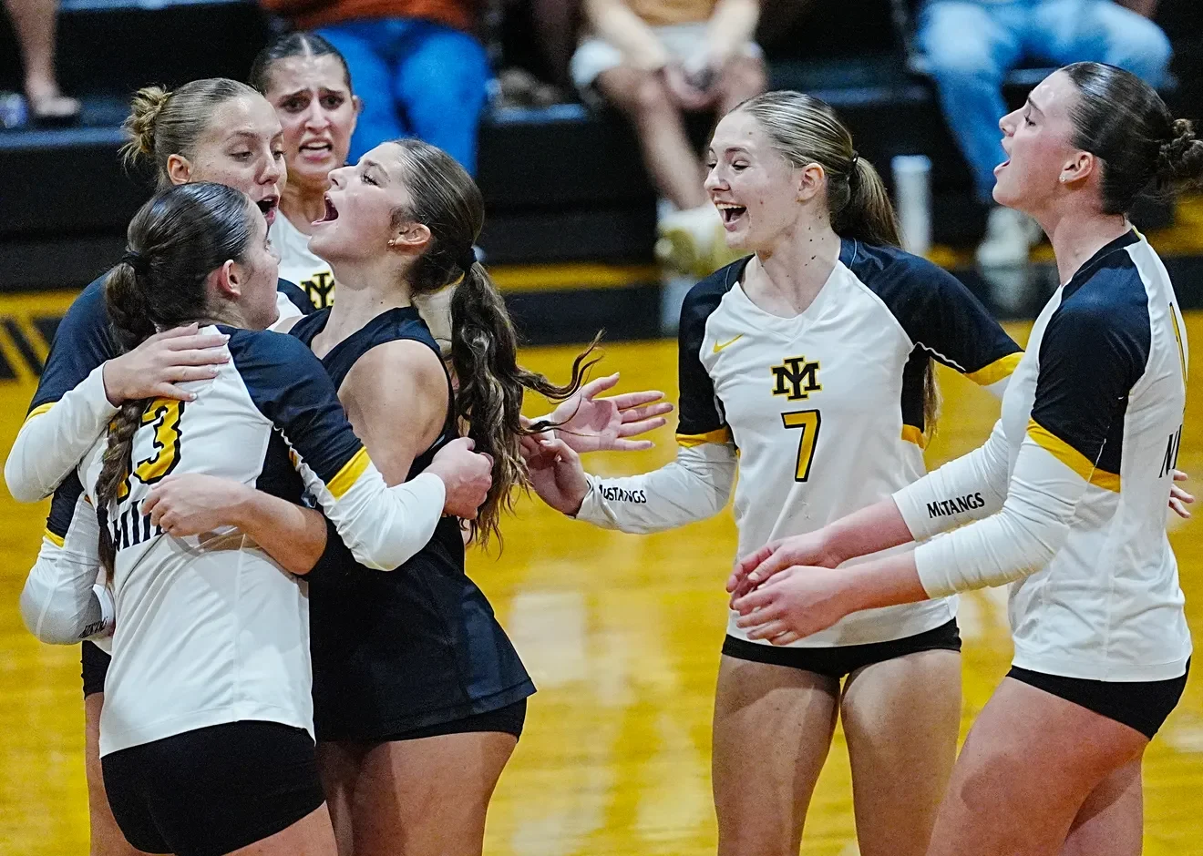 Merritt Island volleyball players celebrate together on the court.
